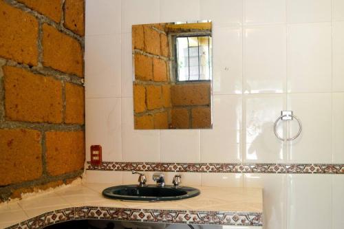 La salle de bains est pourvue d'un lavabo et d'un miroir. dans l'établissement Casa de Piedra, 