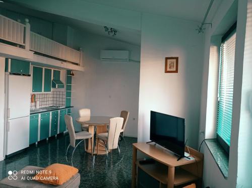 a dining room with a table and a television at OHRID LOFT : The Den in Ohrid