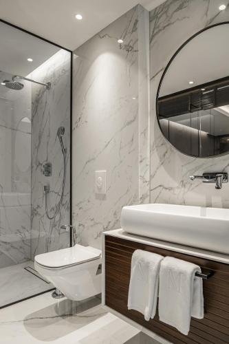 a bathroom with a sink and a toilet and a shower at Hotel MANAMI in Pristina