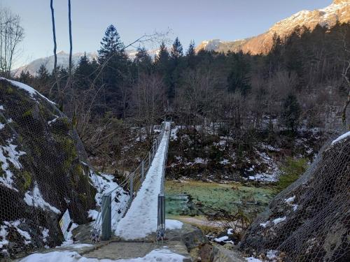 a suspension bridge over a river in the snow at Cozy Apartment Bovec in Bovec