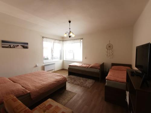a bedroom with two beds and a flat screen tv at Privat Teo Podtureň in Liptovský Mikuláš