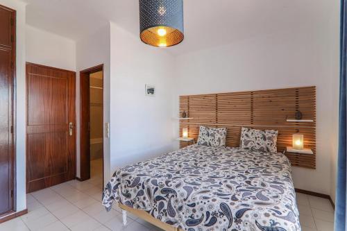 een slaapkamer met een groot bed met een houten hoofdeinde bij Vila Mourisca in Porches