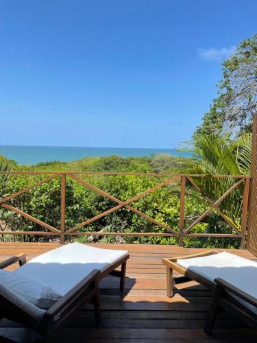 two beds on a deck with a view of the ocean at Hotel Sombra e Água Fresca in Pipa