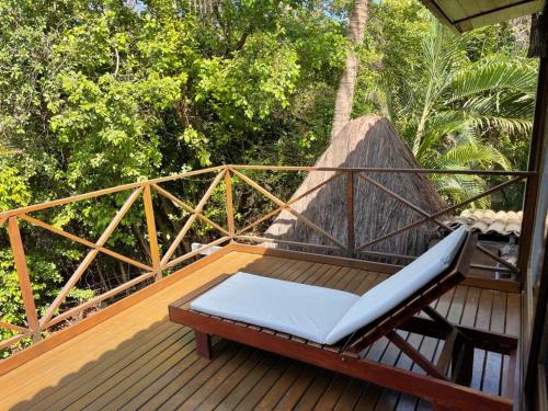 a bench on the deck of a house at Hotel Sombra e Água Fresca in Pipa
