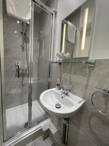 a bathroom with a sink and a shower at The Gateway Hotel in London