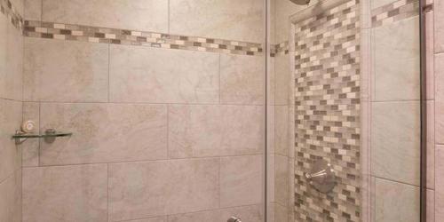 a bathroom with a shower with a glass door at Red Coach Inn in Niagara Falls