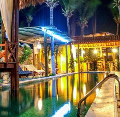 a swimming pool at a resort at night at Ville Sweet Home in Canoa Quebrada