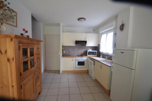a kitchen with white appliances and a white refrigerator at T3 coquet et lumineux aux pieds des pistes in Ancelle