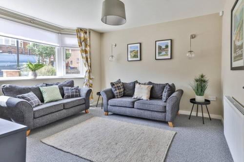 a living room with two couches and a window at Elegant Retreat Nook at Peak District Gateway in Totley