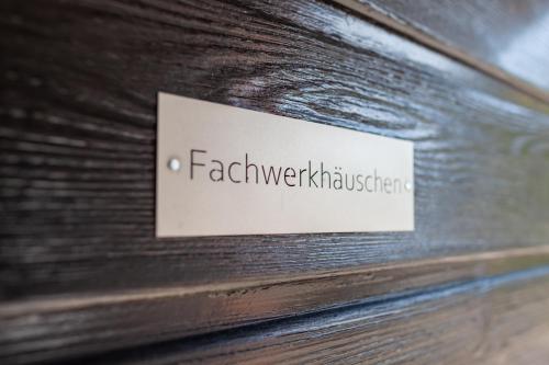 a sign on the side of a wooden book at Fachwerkhäuschen in Enkirch
