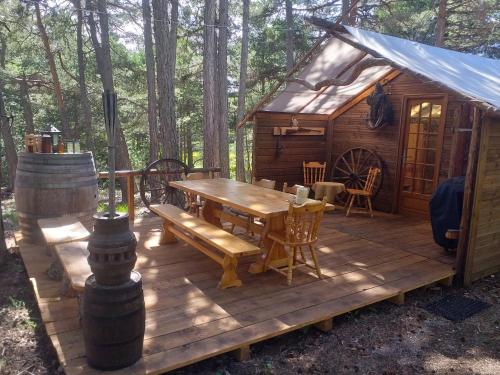 a wooden deck with a wooden table and a tent at Destination Ailleurs in Castellane