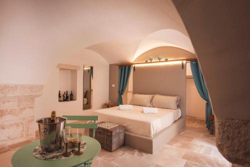 a large bedroom with a bed and a table at Via Roma 32 in Ostuni