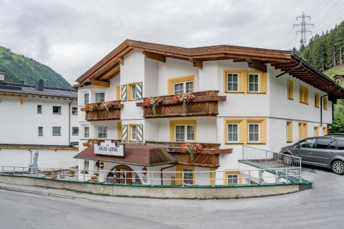 um hotel nas montanhas com um carro estacionado em frente em Arlen Lodge Hotel em Sankt Anton am Arlberg