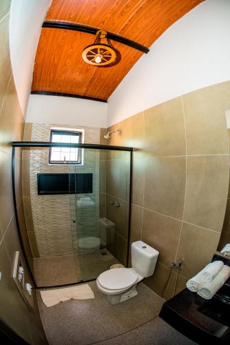 a bathroom with a toilet and a glass shower at Terra Parque Eco Resort in Noite Negra