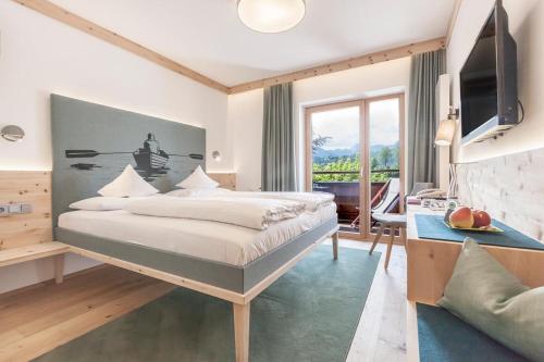 a bedroom with a large bed and a television at Hotel Zur Schanz in Ebbs