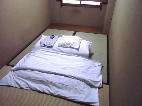 1 cama con sábanas blancas y almohadas en una habitación en Park Inn, en Osaka