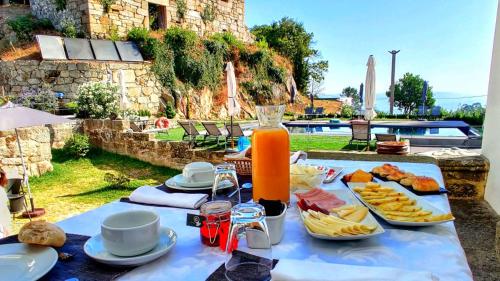 a table with food and orange juice on it at Paço de Vilharigues in Vouzela