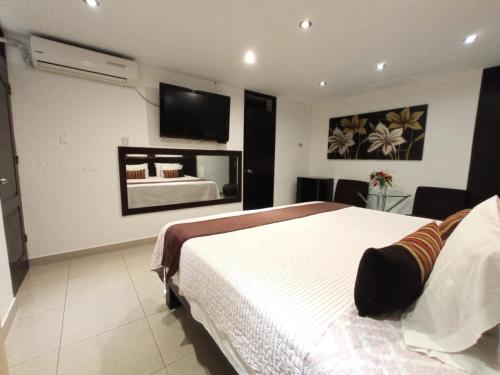 a bedroom with a bed and a tv on the wall at Monterrico Hotel Perú in Lima