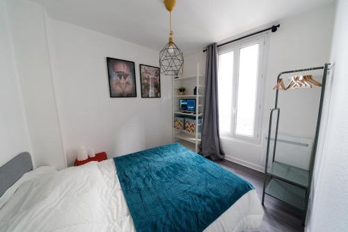 ein Schlafzimmer mit einem Bett und einem großen Fenster in der Unterkunft AppartUnique - Chez Majorelle in Vichy