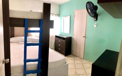 a bedroom with two bunk beds and a room with a ladder at La Quinta Bacana La Campiña in Barranquilla