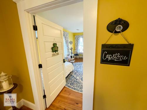 a room with yellow walls and a door with a sign on it at Bama Bed and Breakfast - Capstone Suite in Tuscaloosa