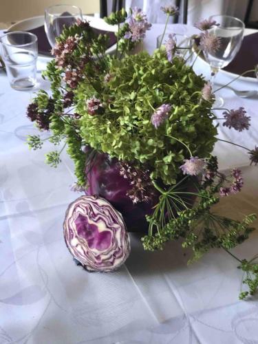 a purple vase with flowers on a table at La Ferme de Châtenoy - Le Mouton Noir in Châtenoy