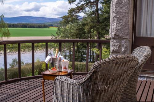 two wicker chairs sitting on a porch with a table at Lys-Na-Greyne in Aboyne
