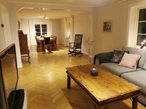 a living room with a couch and a table at Östra Flygeln Grinda Säteri in Malmköping