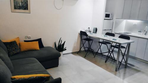 a living room with a couch and a table and a kitchen at On the sea in Ashqelon