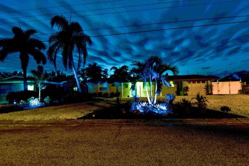 a house with palm trees and lights on a street at Waterfront Bradenton Home Heated Pool and Fire Pit in Bradenton