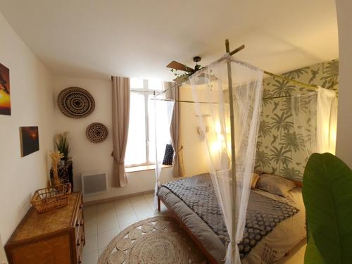 1 dormitorio con cama con dosel y ventana en Le Lude Land Lodge en Le Lude