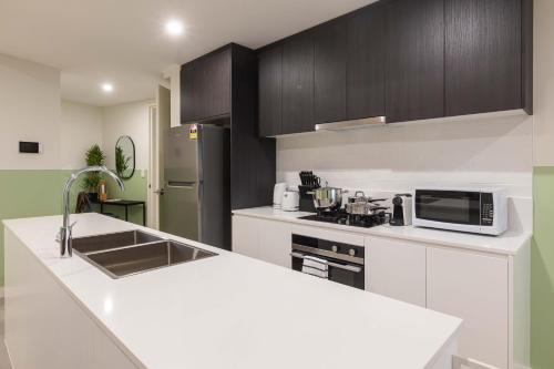 Kuchyň nebo kuchyňský kout v ubytování KULA Apartments Parramatta