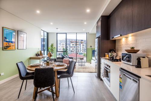 uma cozinha e sala de jantar com mesa e cadeiras em KULA Parramatta em Sydney