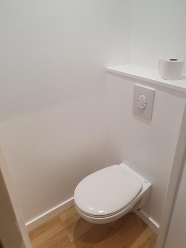 een wit toilet in een badkamer met een plank bij Emeraude Jacuzzi in Saint-Malo