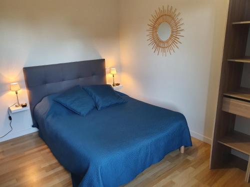een slaapkamer met een blauw bed en een spiegel bij Emeraude Jacuzzi in Saint-Malo