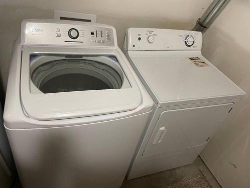a washing machine and a washer in a room at Spacious Basement suite in Camrose