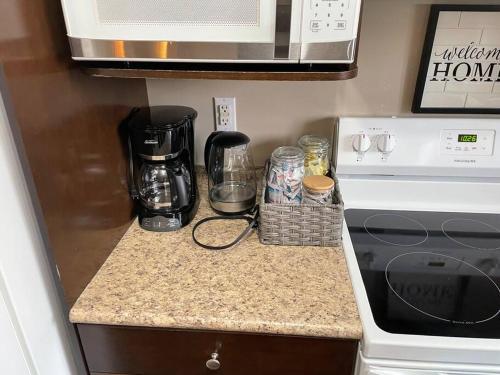 a kitchen counter with a coffee maker and a microwave at Spacious Basement suite in Camrose
