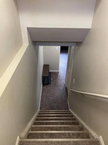a hallway with stairs and a table in a building at Spacious Basement suite in Camrose