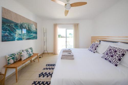 een slaapkamer met een groot wit bed en een ventilator bij Casa da costa in Carrapateira