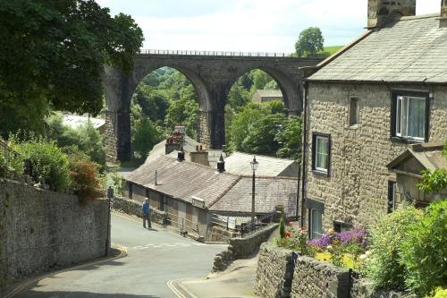 a man walking down a street with a bridge in the background at Dalecote Barn Bed and Breakfast (Bunkroom) in Ingleton