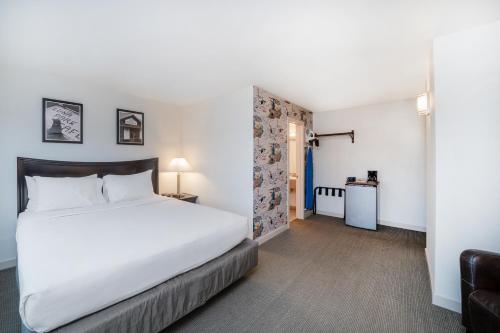 um quarto com uma grande cama branca e um sofá em The Grove West Seattle Inn em Seattle
