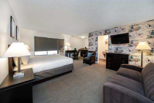 a hotel room with a bed and a couch at The Grove West Seattle Inn in Seattle