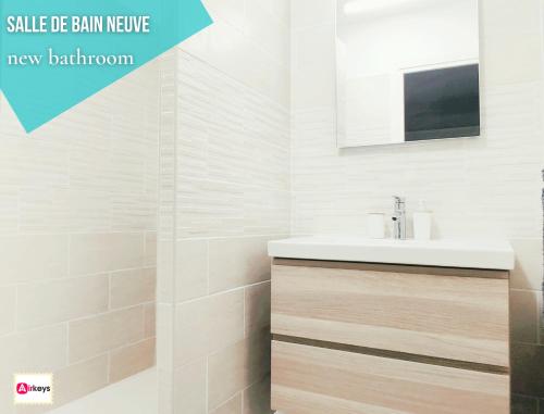 une salle de bain blanche avec un lavabo et un miroir dans l'établissement Grand Studio Azur avec terrasse - Vieil Antibes, à Antibes