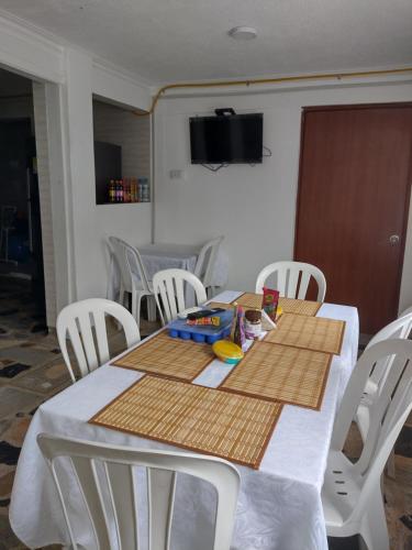 Una mesa de comedor con sillas blancas y una mesa blanca con una mesa. en Hotel Bogotá Airport, en Bogotá