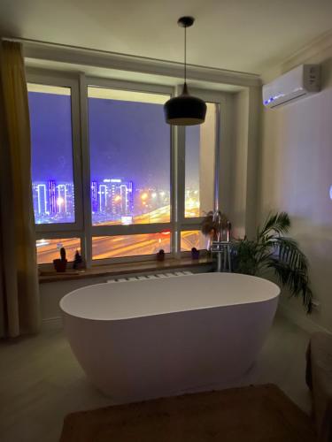 una gran bañera blanca en una habitación con ventana en Апартаменти з неймовірною ванною, en Kiev