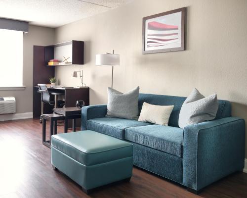 a living room with a blue couch and a stool at Comfort Inn & Suites Pottstown Eastern Gateway in Pottstown