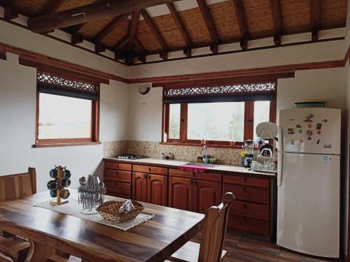 eine Küche mit einem Holztisch und einem Kühlschrank in der Unterkunft Casa Campestre Flores Amarillas in Villa de Leyva