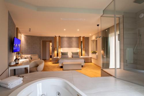 a bathroom with a tub and a living room at San Severino Park Hotel & SPA, BW Signature Collection in Mercato San Severino