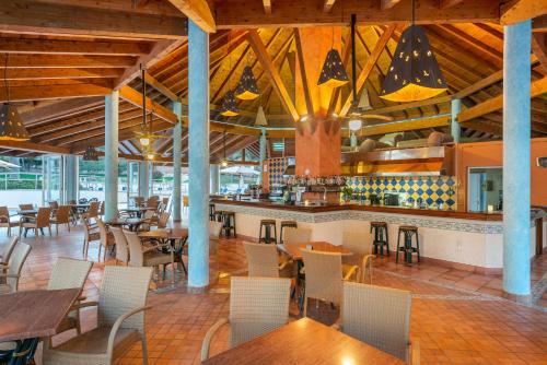a restaurant with tables and chairs and a bar at Can Picafort Palace in Can Picafort