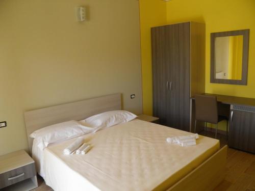 een slaapkamer met een bed met twee handdoeken erop bij B&B Mare & luna in San Sostene